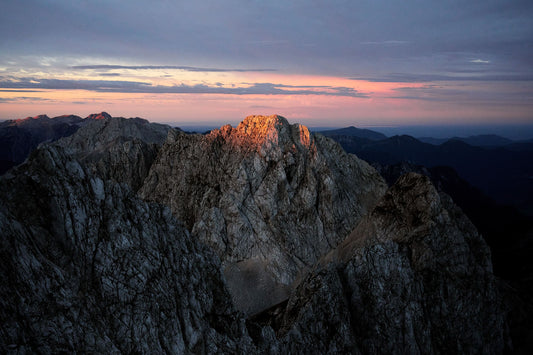 The artpiece 'Change' by Chris König shows a mountainvista of the Julian Alps with a red sky in the background.