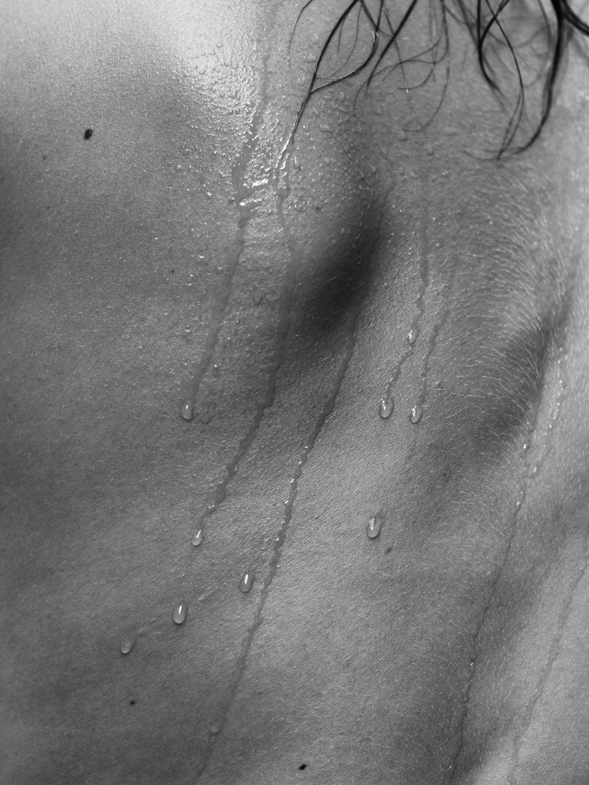 Gianluca Fontana's 'Drops' - Abstract monochrome photograph of wet drops on a bare back, strands of wet hair, and water droplets, part of the Krops collection, created in Paris, 2017.