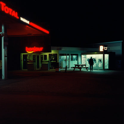 The artwork 'Exterior #10' by Jildo Tim Hof displaying a gas station late at night with one lonely visitor