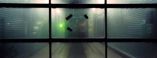 The artwork 'Exterior #3' by Jildo Tim Hof portraying a carwash as seen from the misty garagedoor, looking in from the dark outdoors