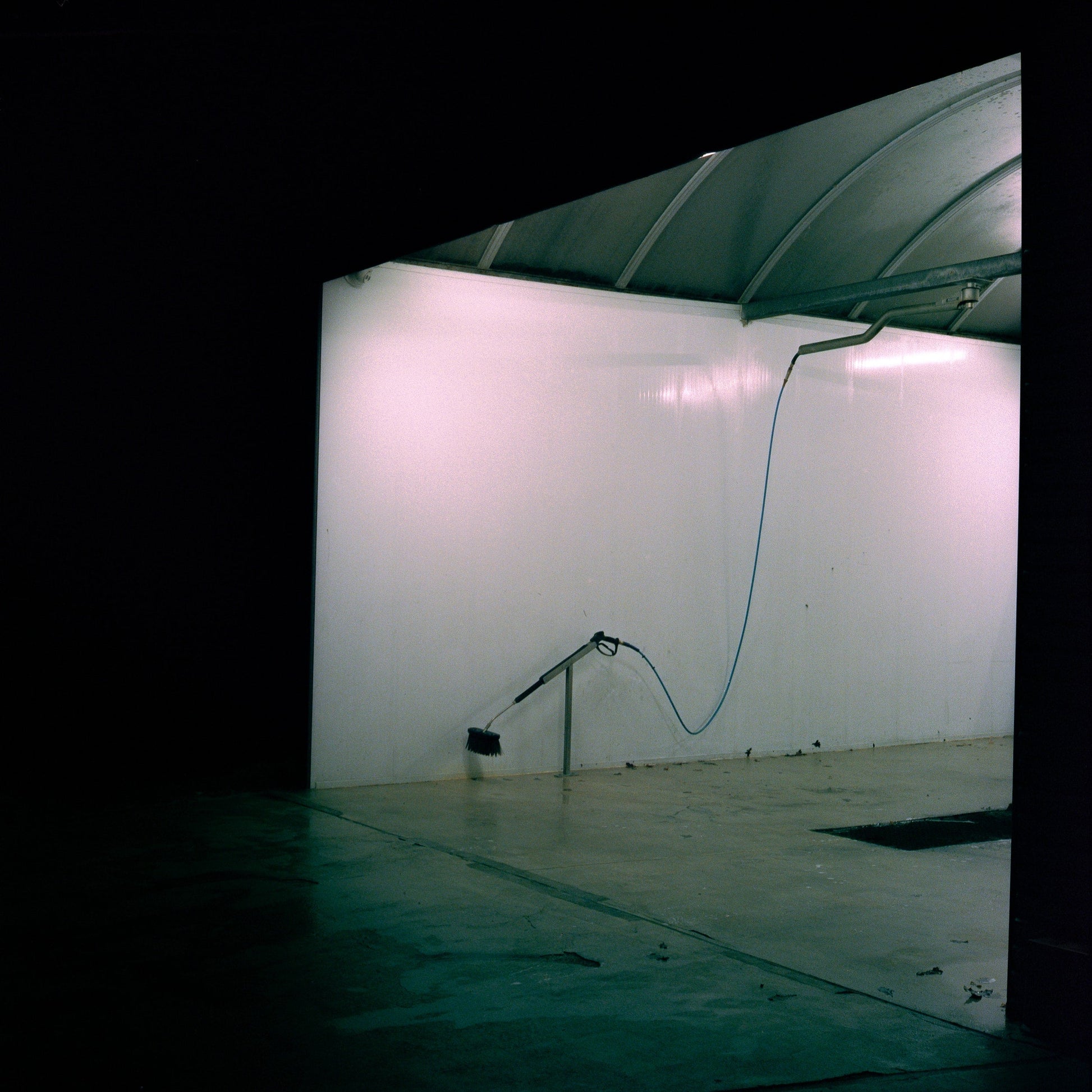 The artwork 'Exterior #6' by Jildo Tim Hof portraying a carwash, looking in from the dark outdoors
