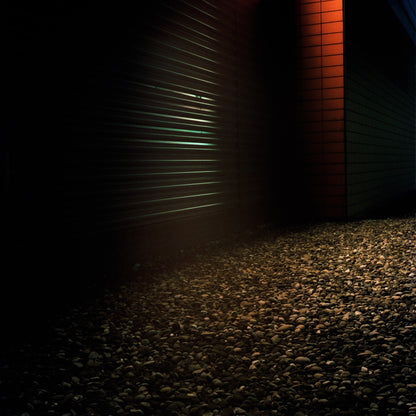 The artwork 'Exterior #8' by Jildo Tim Hof showing gravel in front of a dimly lit industrial looking building