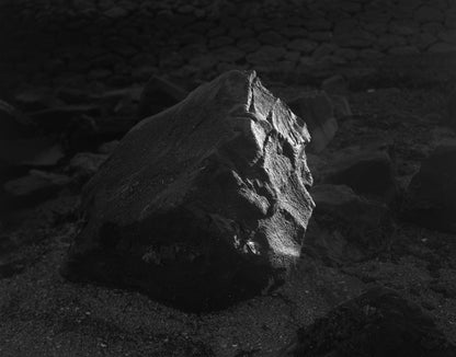 The artwork 'Concrete #3' by Jildo Tim Hof showing a rock with one side shrouded in darkness and the other reflecting the light