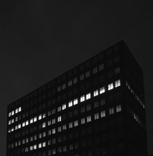 The artwork 'Concrete #7' by Jildo Tim Hof showing a partially lit up concrete office building at night
