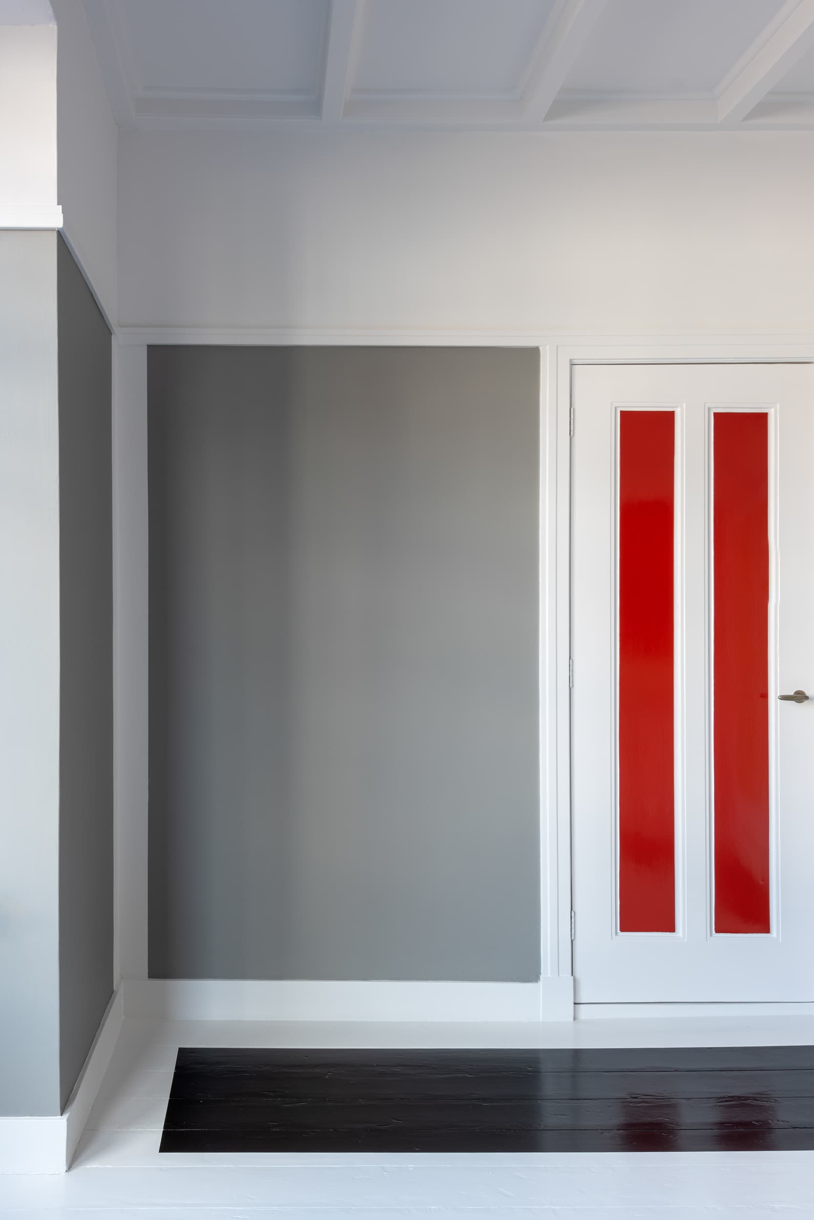 The artwork 'Van Doesburg-Rinsemahuis #1' by Jildo Tim Hof showing A grey wall in a corner with a red striped door