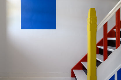 The artwork 'Van Doesburg-Rinsemahuis #3' by Jildo Tim Hof displaying a multicolored staircase against a white wall