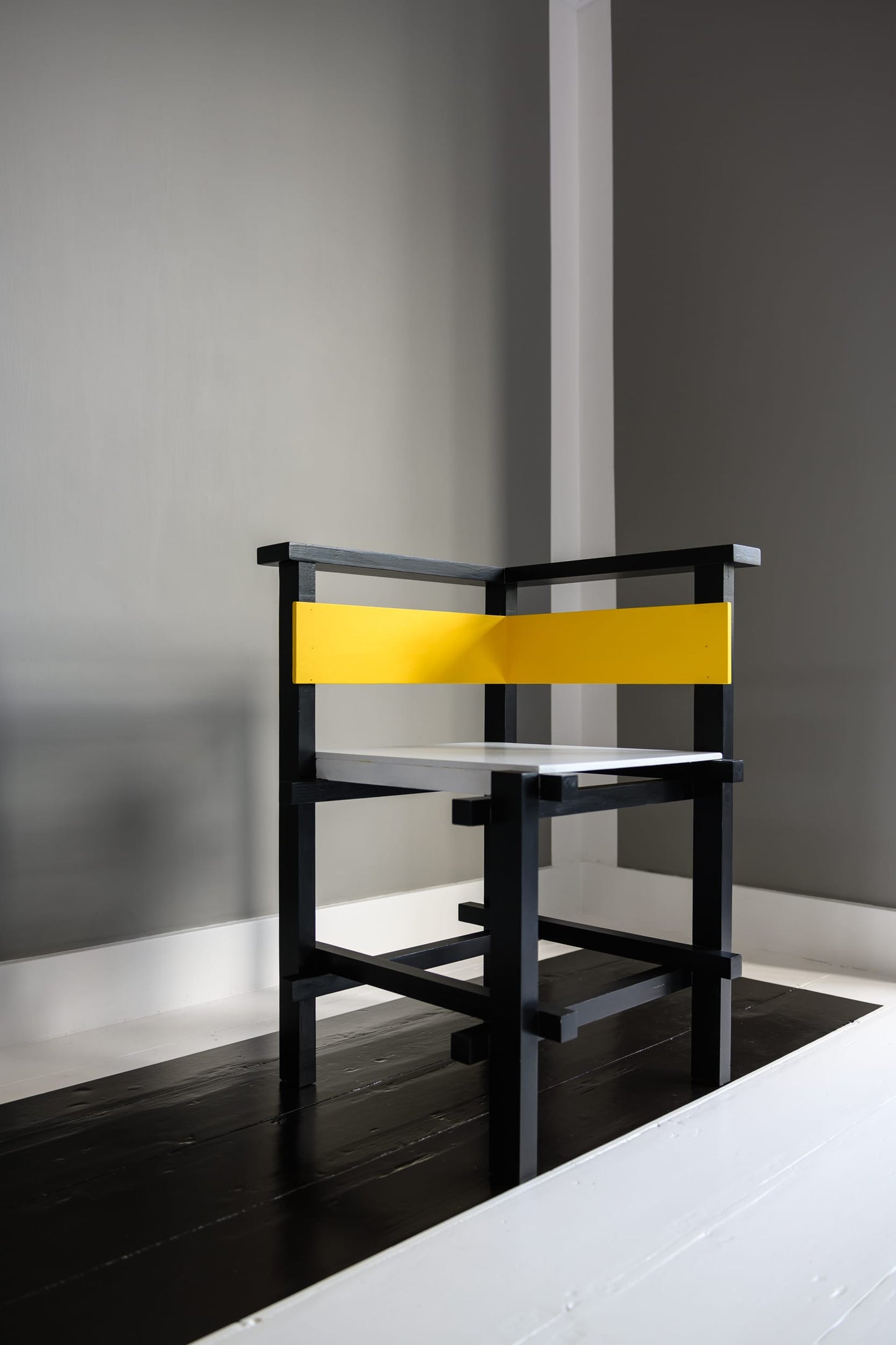 The artwork 'Van Doesburg-Rinsemahuis #5' by J.T. Hof displaying a lonely black and yellow chair in a corner