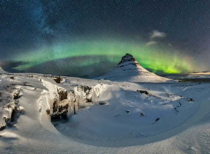 The artpiece 'Alheimsins' by Markus van Hauten shows a snowy landscape with a curved aurora in the background.