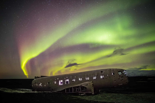 The artpiece 'Flugvél' by Markus van Hauten showing a large bright green aurora over the skies of Iceland.