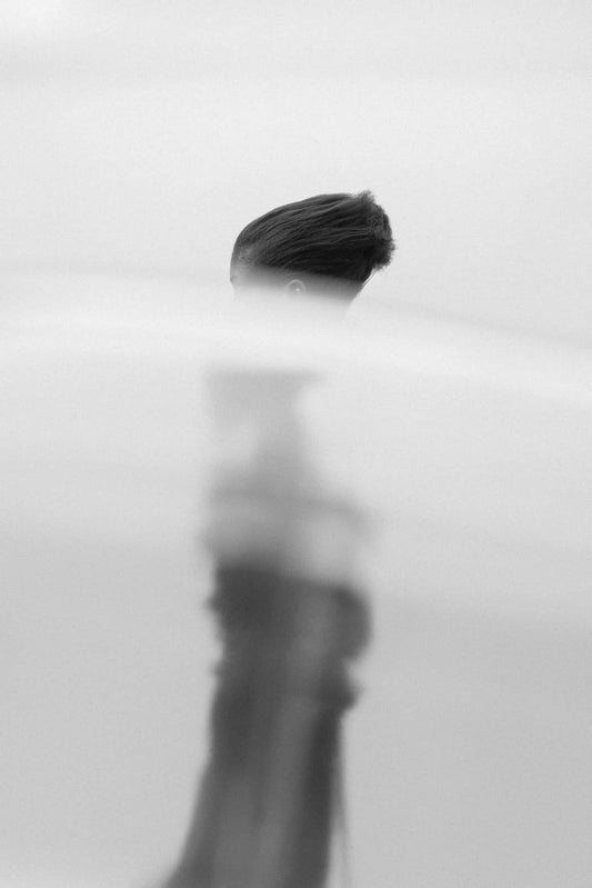 The artpiece 'Equité' by Mathieu Puga shows a side profile of a woman. The upper part of the image is in focus and the further down you move the blurrier the image gets. In the foreground is fog, covering most of the silhouette, only allowing for glimpses to be seen.