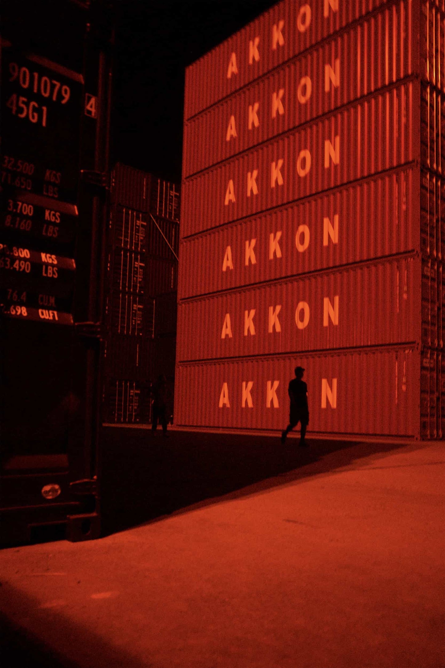 The artpiece 'Containers' by Michael Cai which shows a worker walking by a stack of red containers.