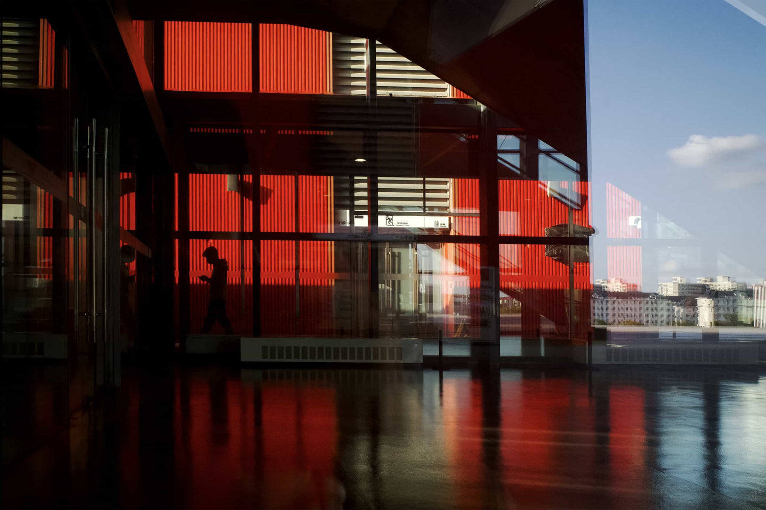 The artpiece 'Reflection' by Michael Cai which shows a black and red image of a building with a glass wall, which reflects the building structure.