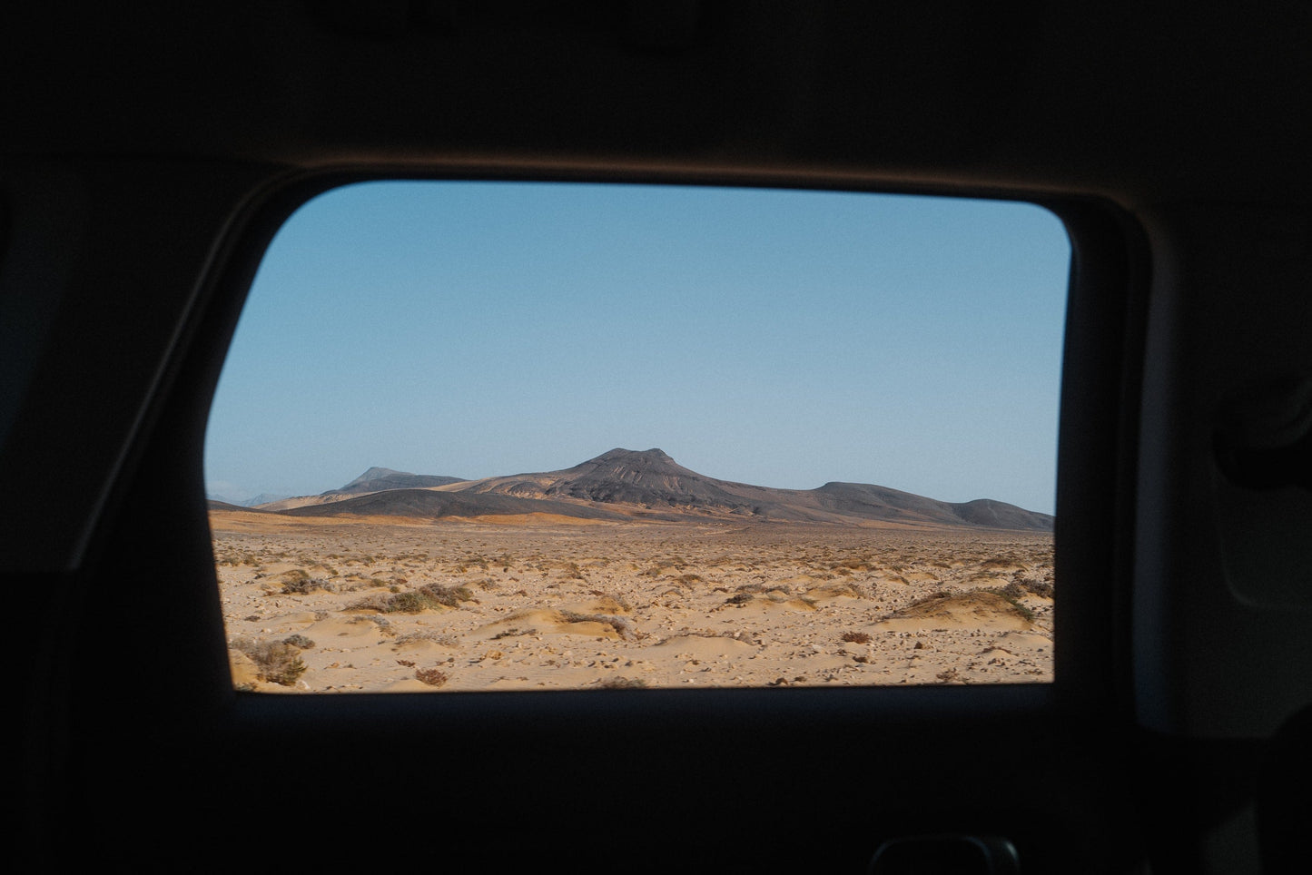 The artpiece 'Volcano' by Mikail Sahin shows a volcano in background, photographed from a car, with the window frame framing the volcano.